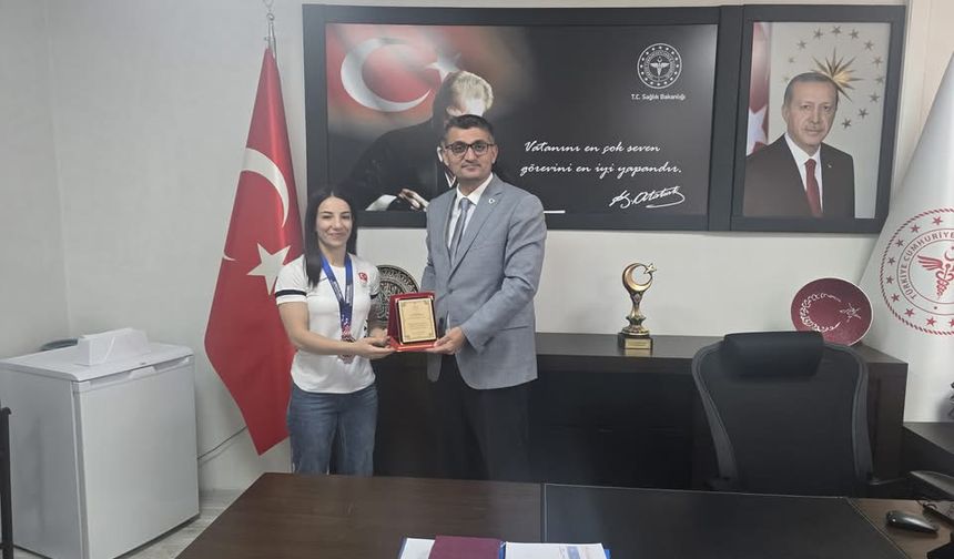 İl Sağlık Müdürü Hacıoğlu’ndan Milli Sporcuya Plaket ve Çiçek Takdimi